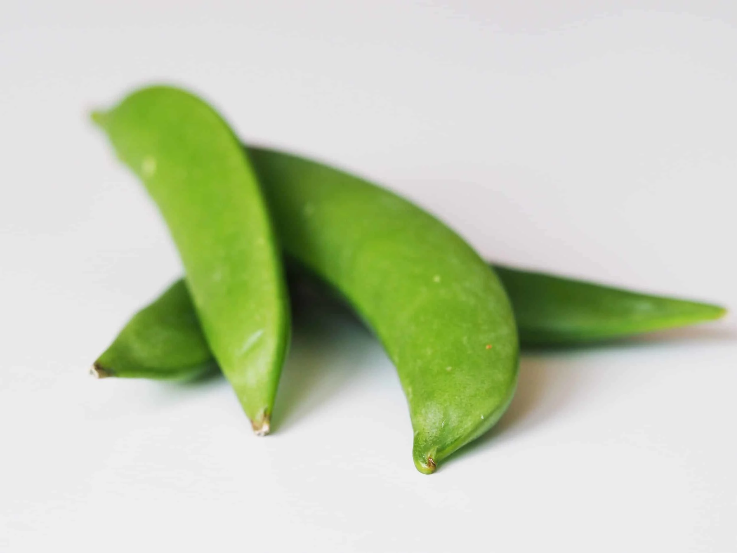a pile of snap peas before being served to babies starting solids