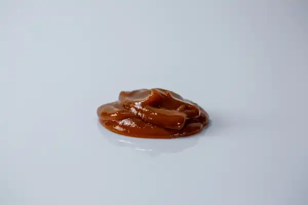 a small pile of red ketchup on a white background
