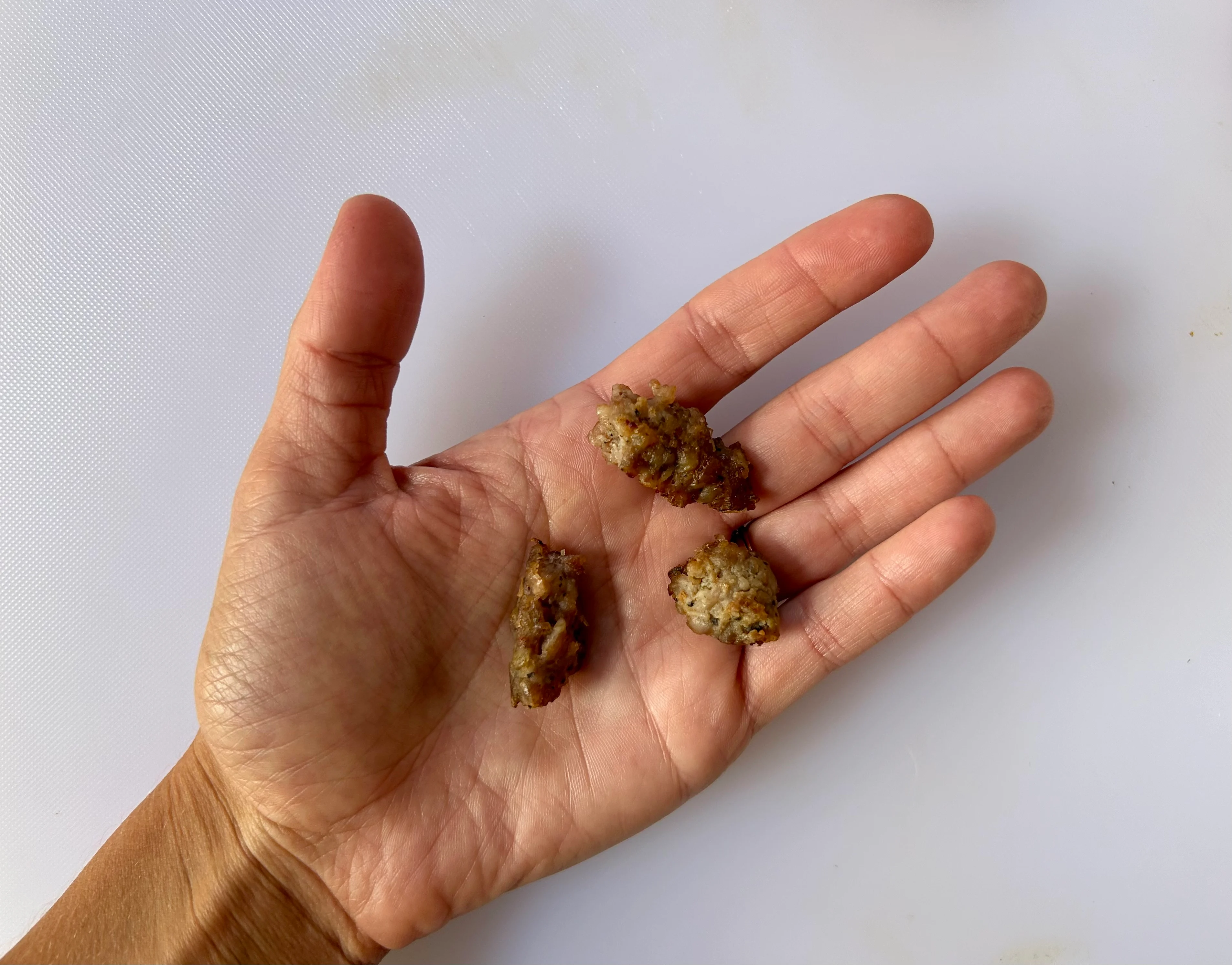 Sausage bite-sized pieces of sausage patty hand pic