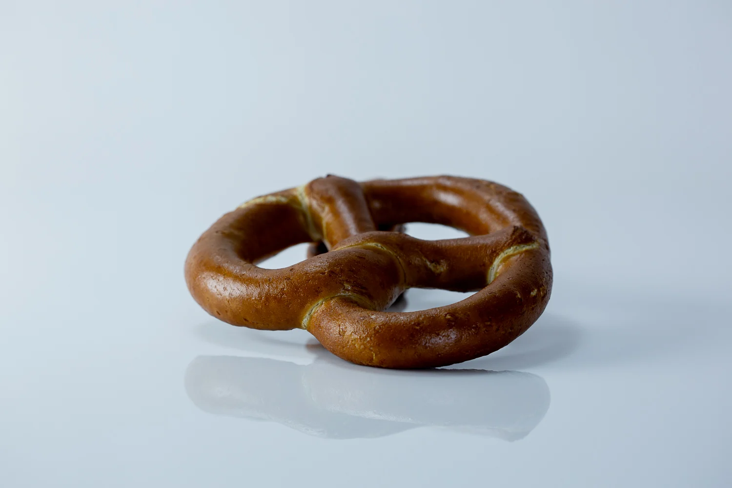 a photograph of a large soft pretzel on a white background