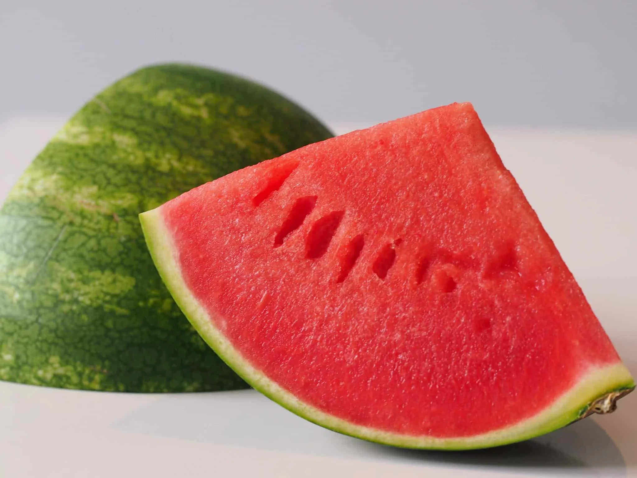 Chunks of watermelon with the rind on and seeds removed being prepared for a baby starting solid foods