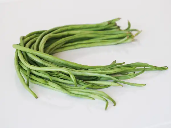 a bunch of raw yardlong beans on a white background