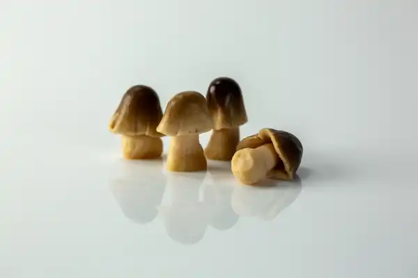 four cooked whole straw mushrooms on a white background