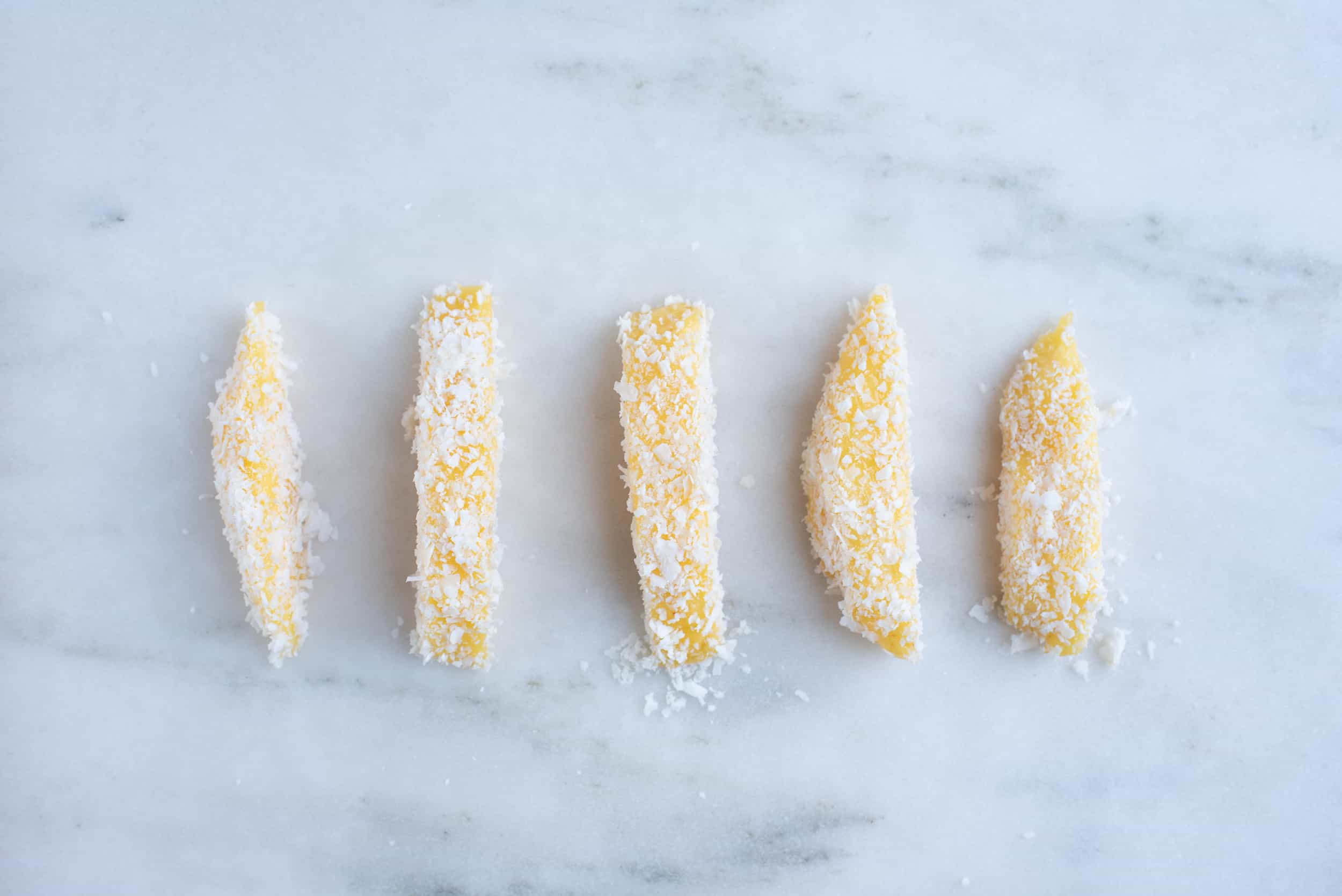 five spears of peeled mango, coated in a tamarind marinade and rolled in coconut flakes
