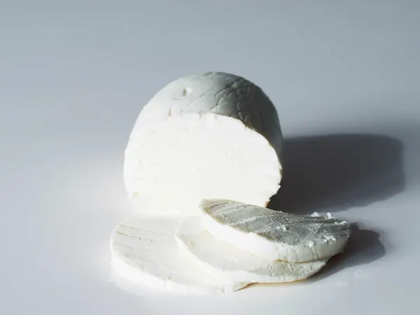 a ball of fresh mozzarella with three slices cut before being prepared for babies starting solid food