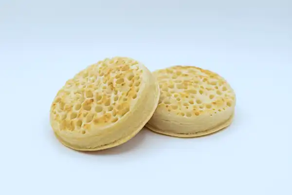a photograph of two toasted crumpets on a white background