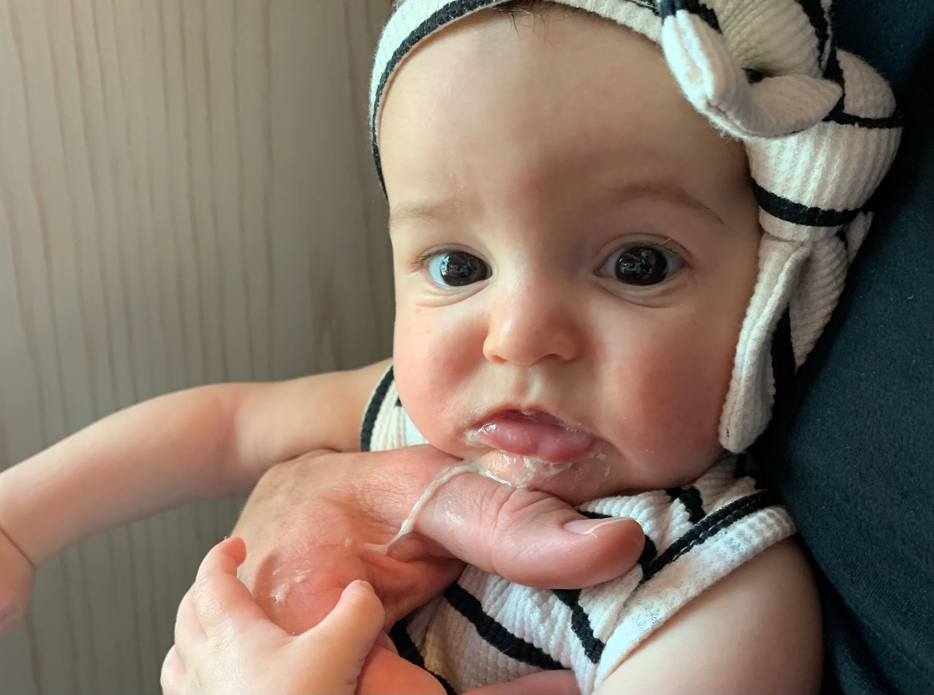 a photograph of a young baby with a bit of spit up on her chin