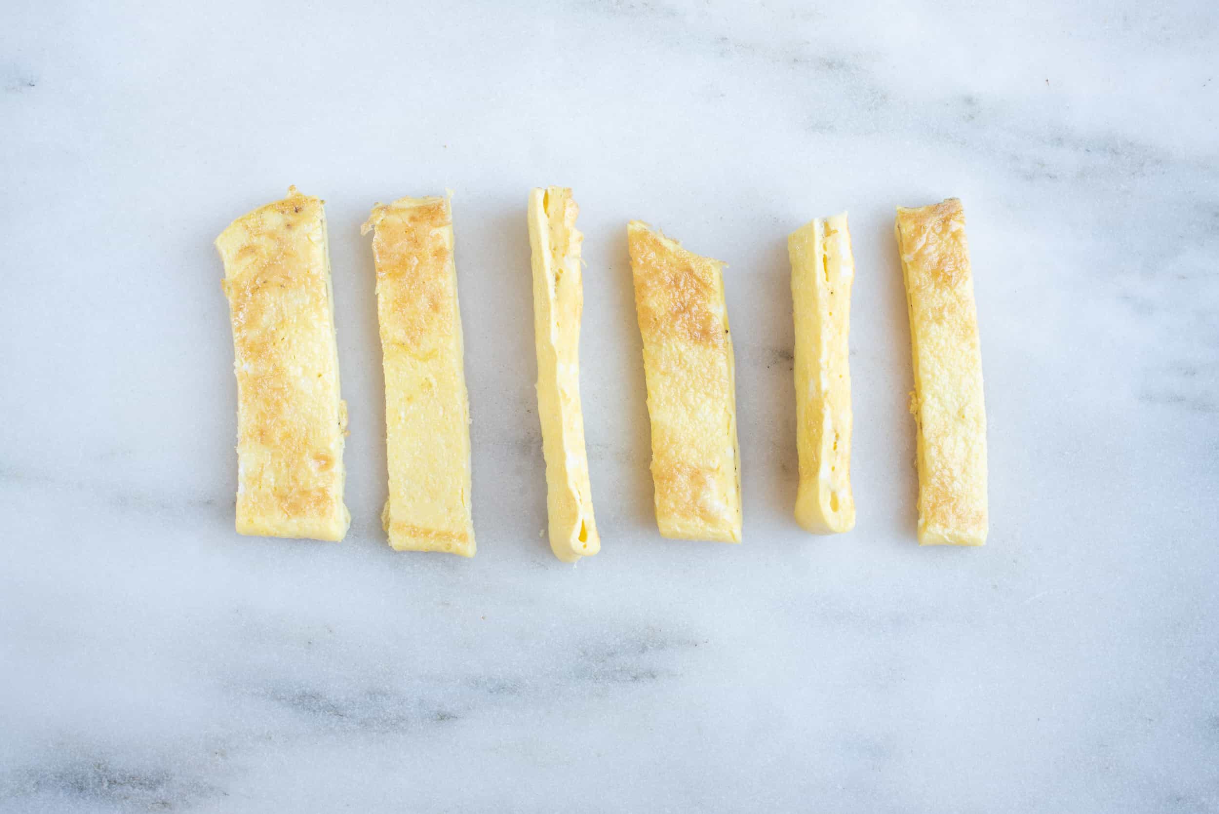 an omelet cut into strips on a white background for 6 month old babies