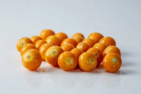 23 whole ripe goldenberries on a white background