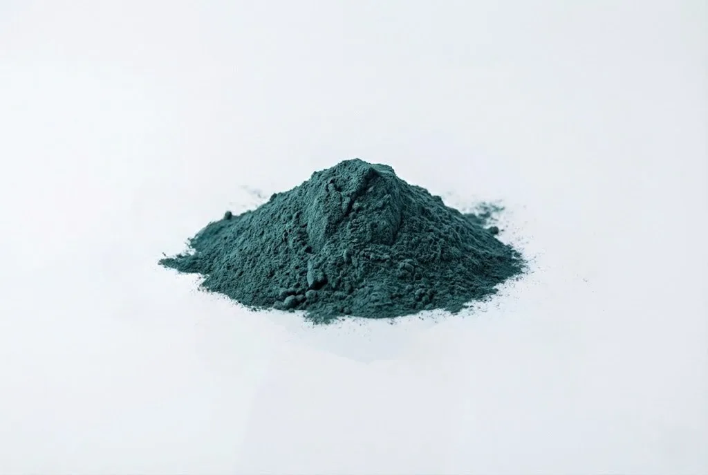 a small pile of powdered spirulina on a white background