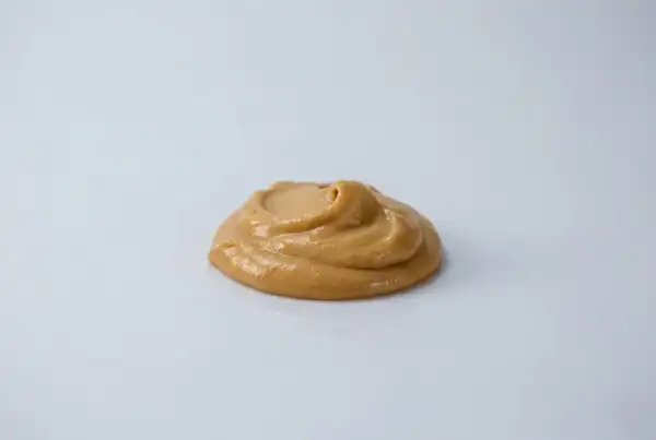 When can babies have peanut butter a photograph of a blob of smooth peanut butter on a white background