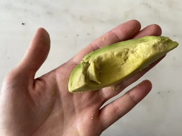 one peeled avocado spear in a hand