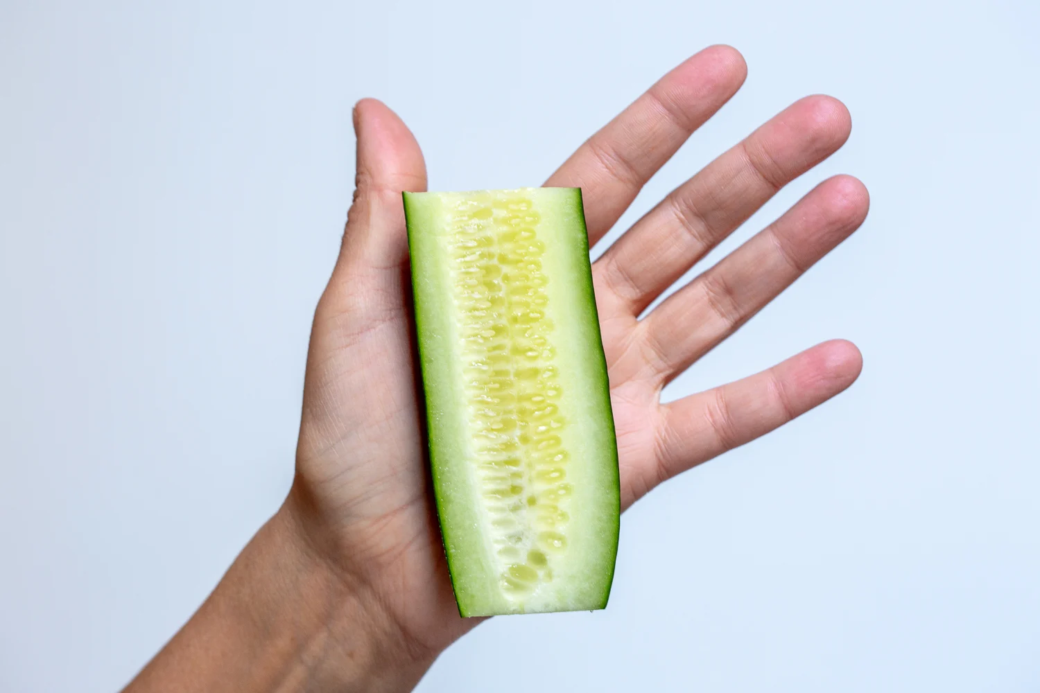 Cucumber halved lengthwise hand pic