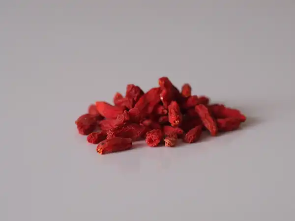 a photograph of a small pile of dried goji berries on a white background
