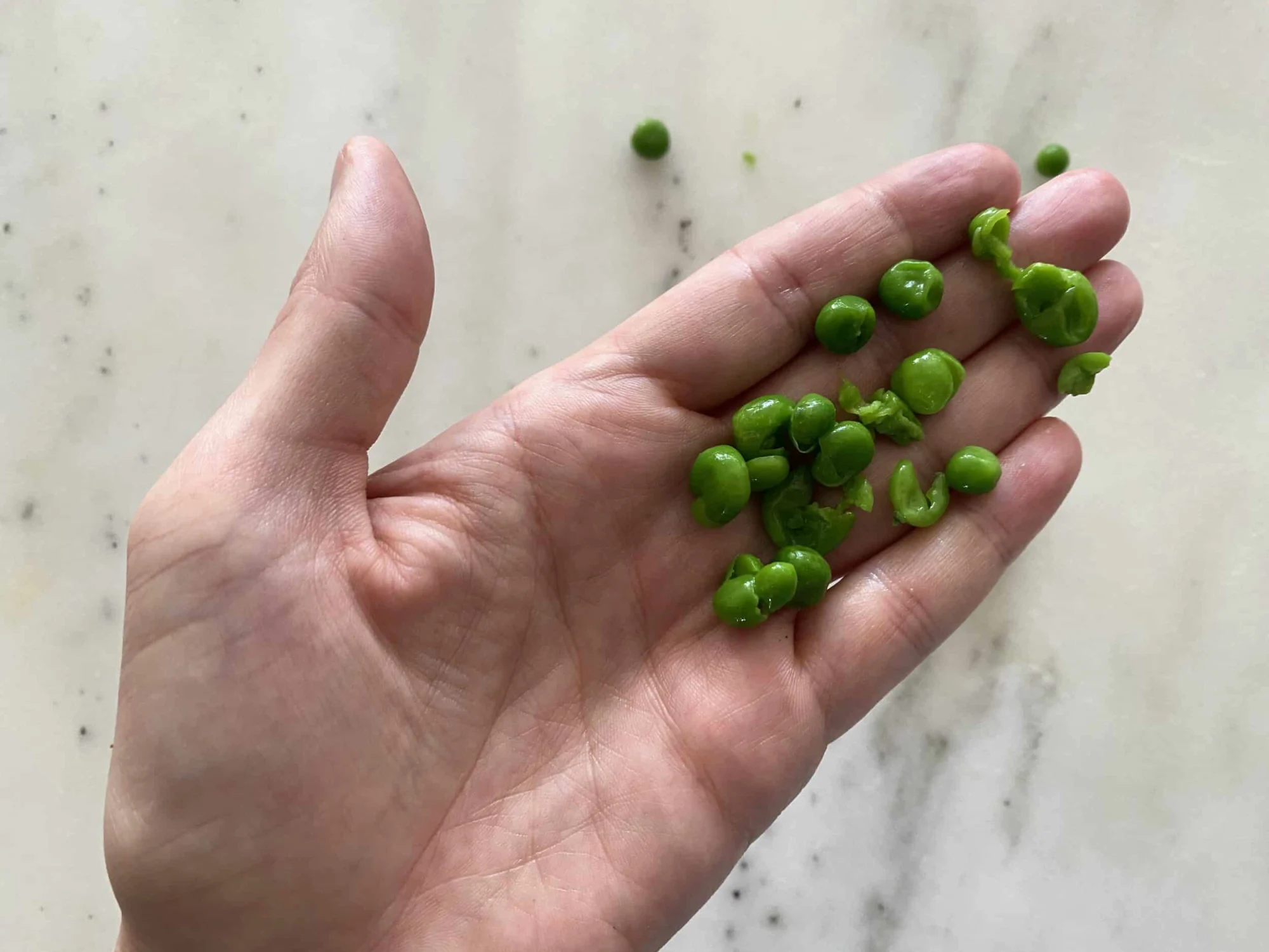 a handful of peas that have been flattened with a fork