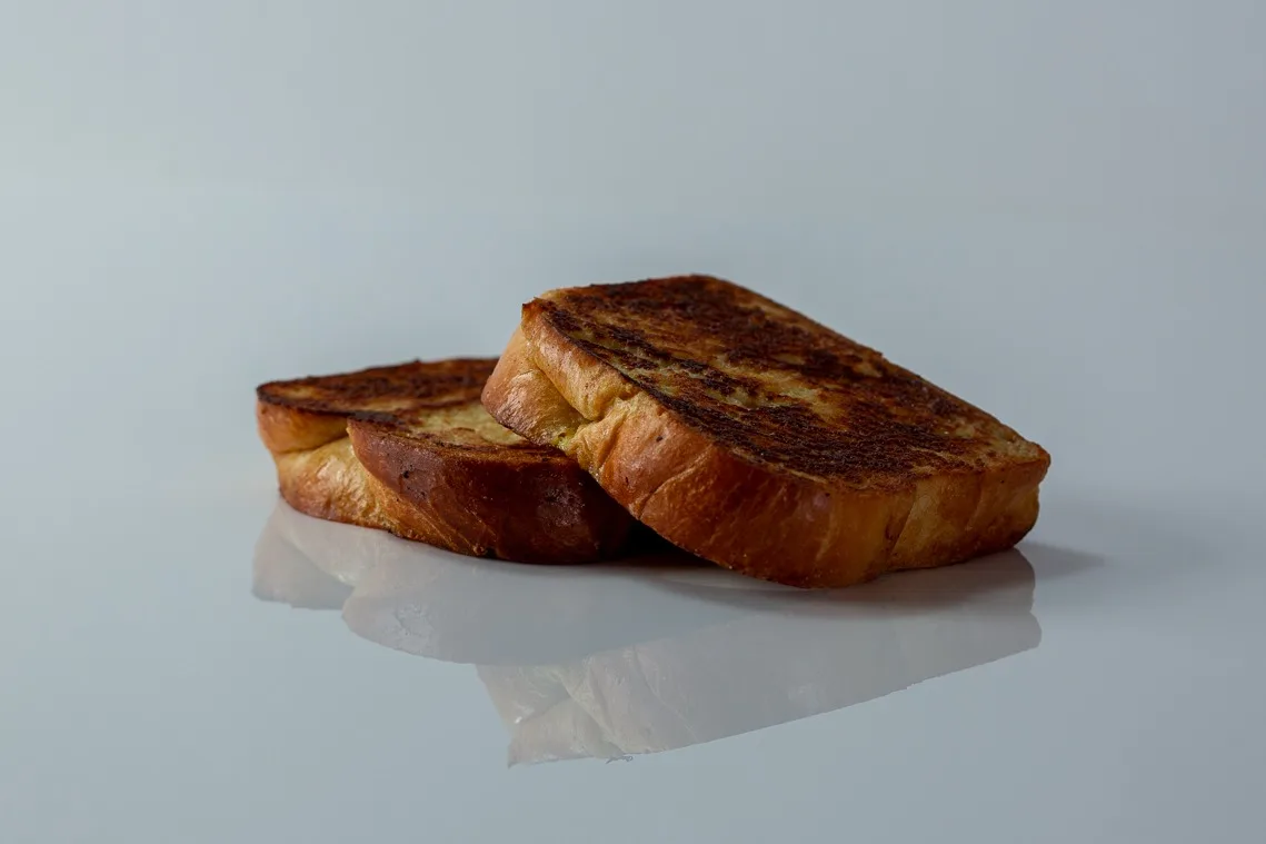 two slices of french toast, one stacked on top of the other, on a white background