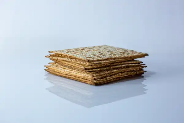a pile of whole matzah crackers on a white background
