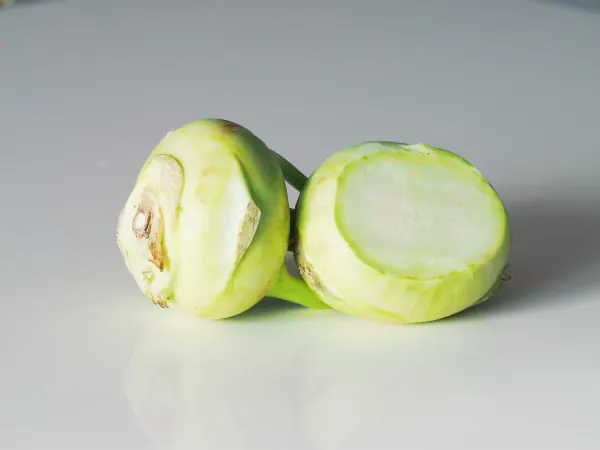 two kohlrabi bulbs, cut open, on a table before being prepared for babies starting solid food