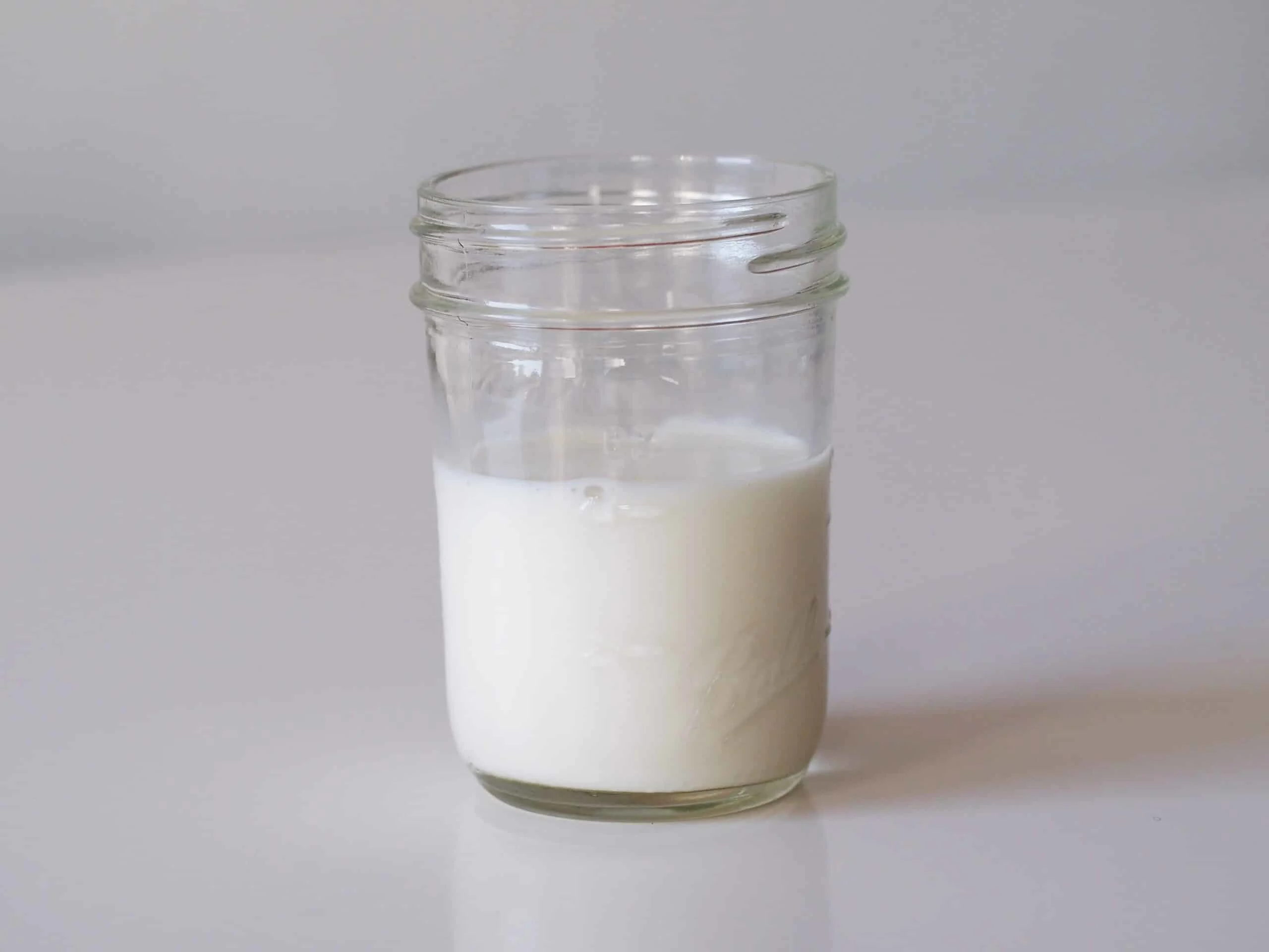 a glass mason jar with kefir in it