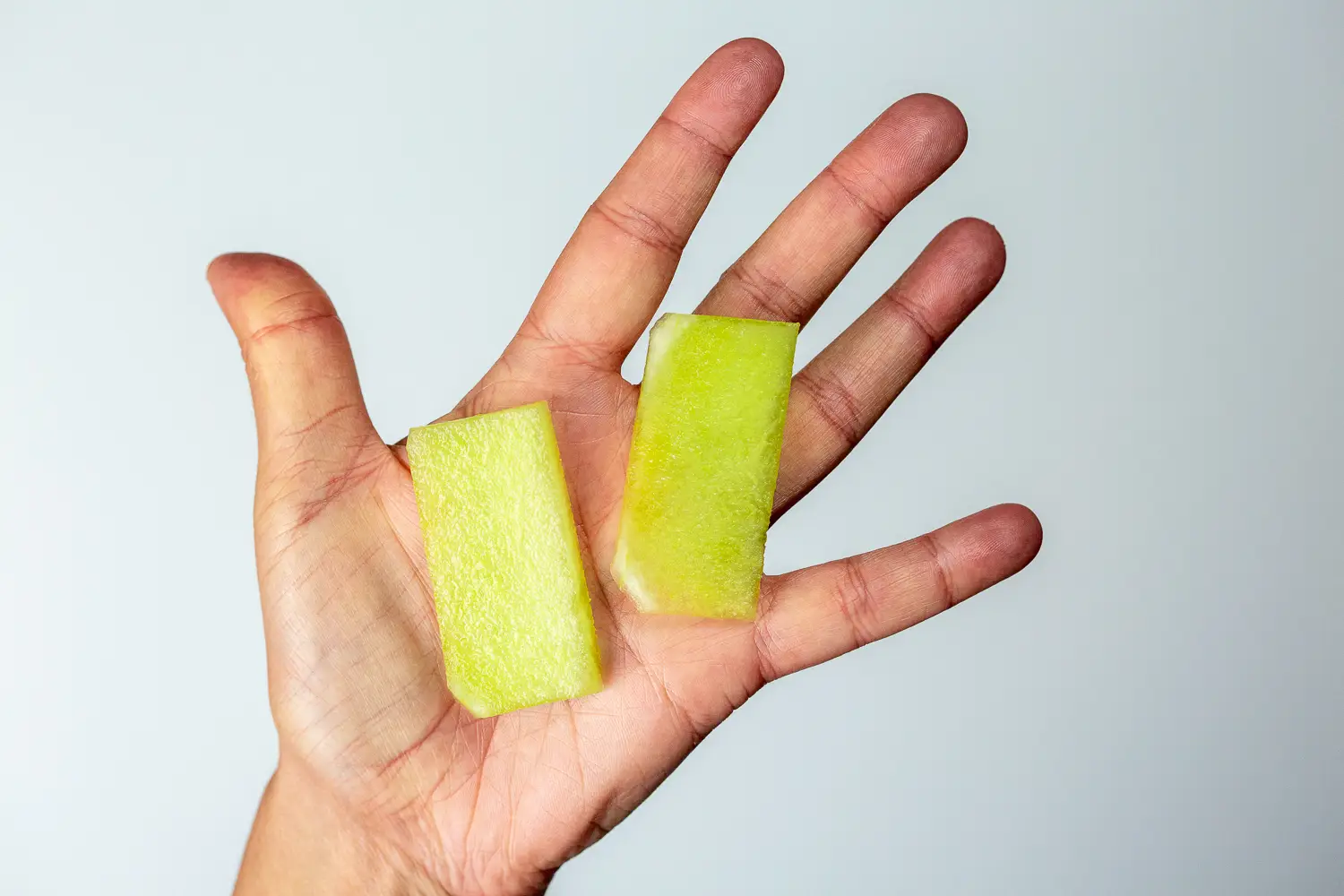 A ruler thin slice of honey dew melon in a hand
