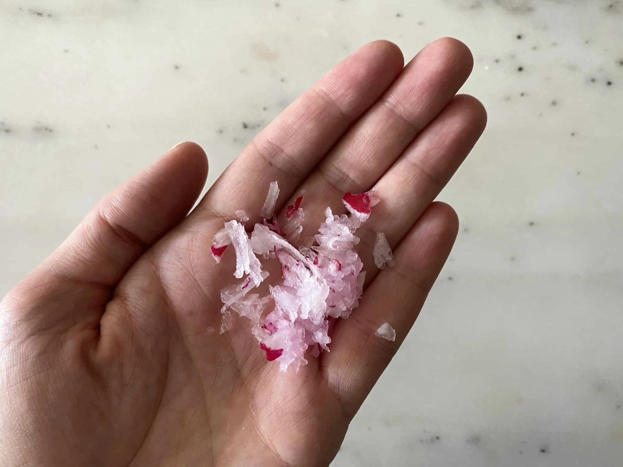palm of hand holding pile of raw grated radish