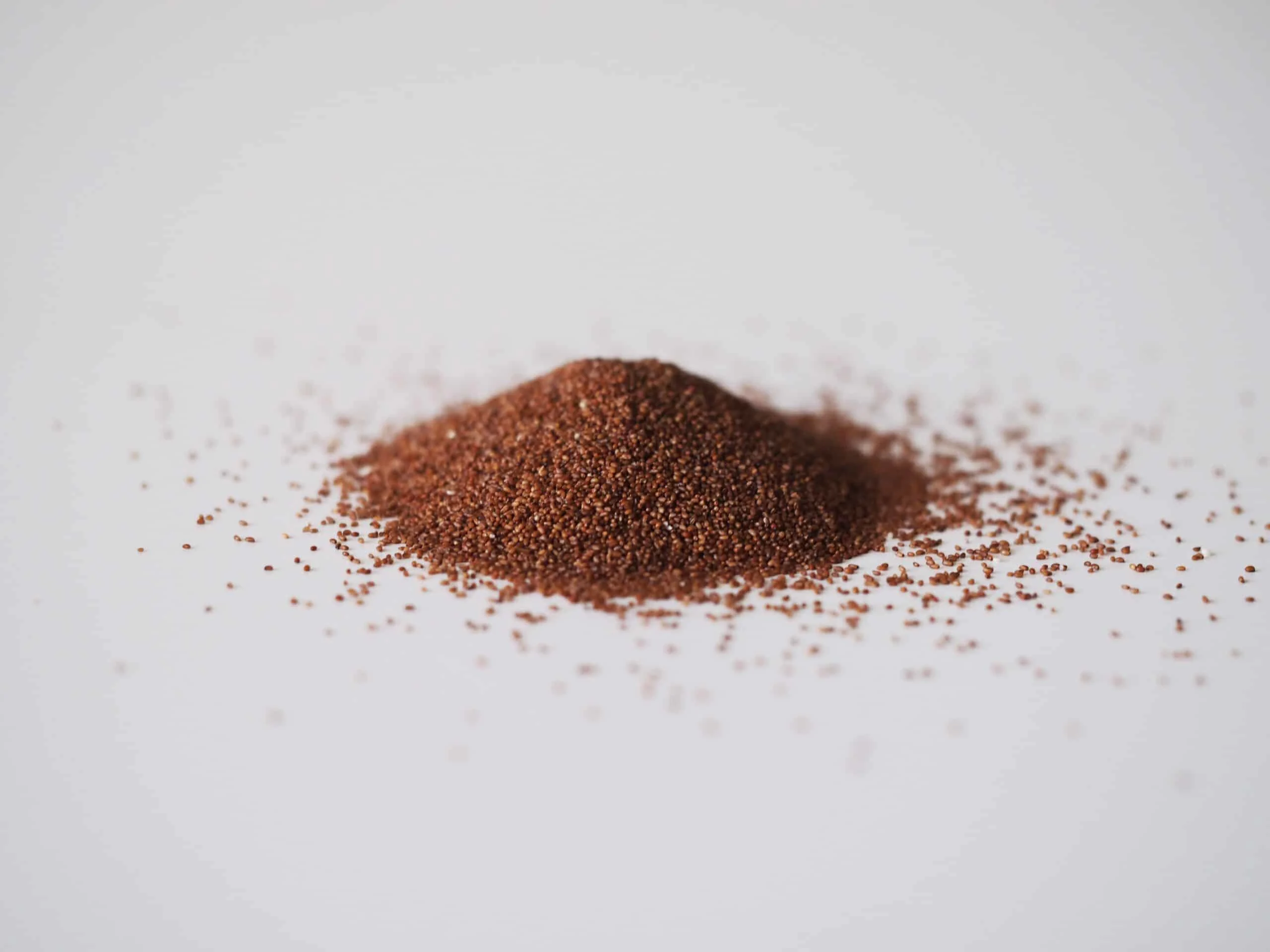 a small pile of teff grains on a white background ready to be cooked for babies starting solids
