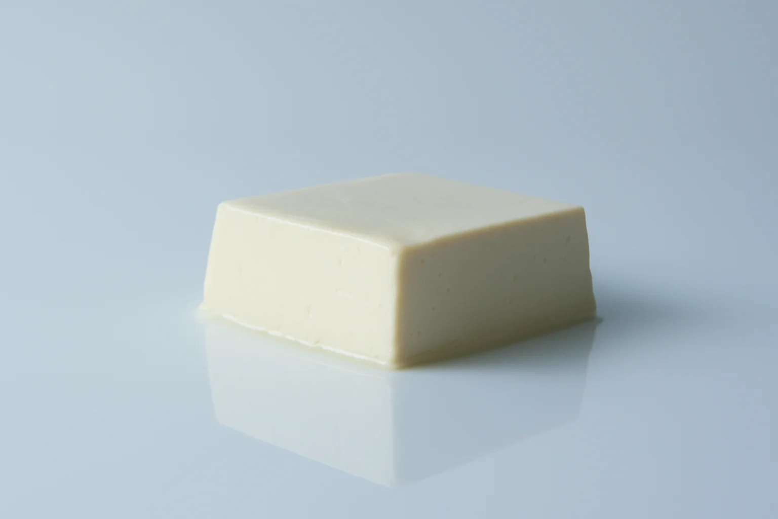 a photograph of a block of soft silken tofu on a white background