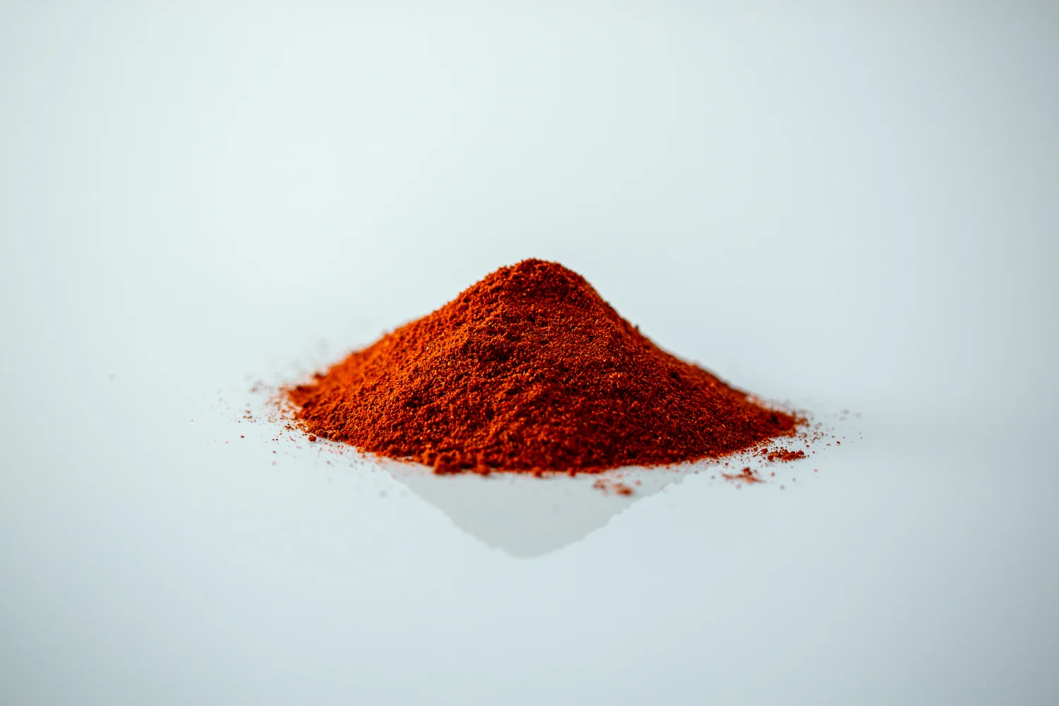 a photo of a pile of powdered red paprika on a white background