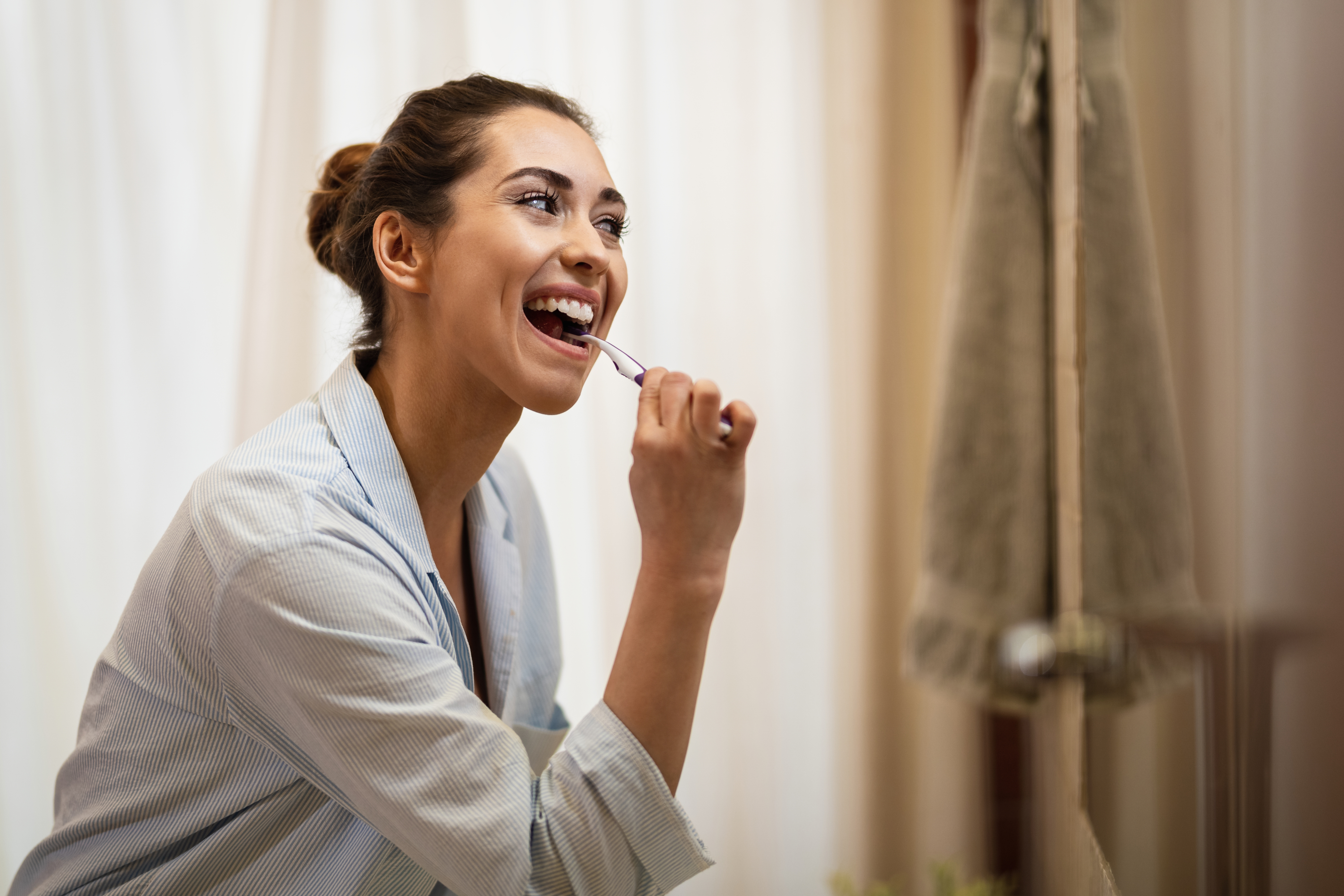 happy-woman-cleaning-her-teeth-with-toothbrush-morning