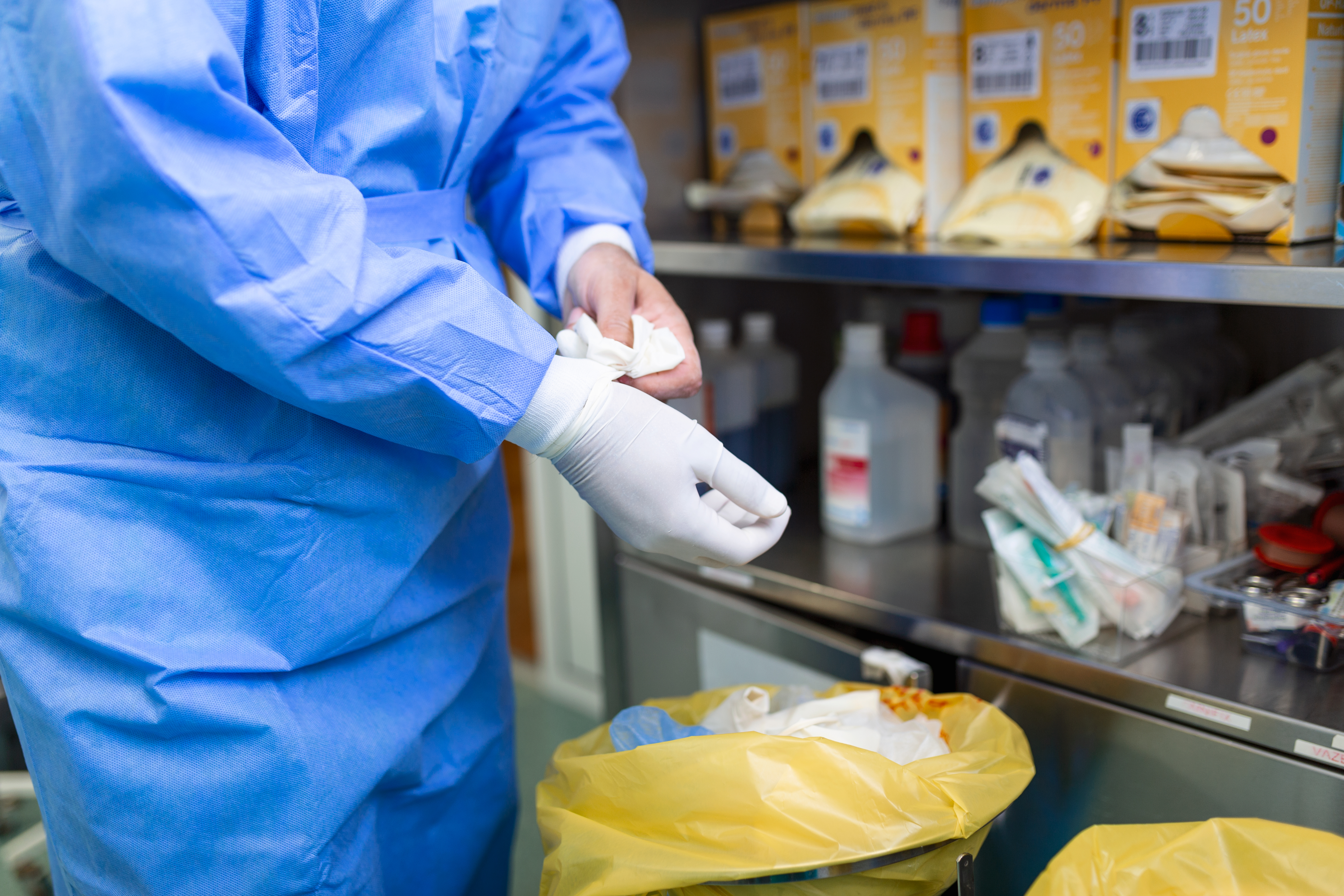 male-surgeon-removing-surgical-gloves-operation-theater-hospital