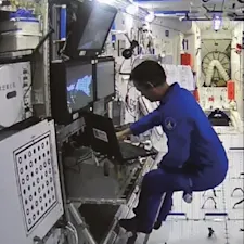 Chinese astronaut operating robotic arm