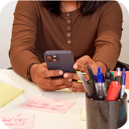 A person holding their phone in a workshop