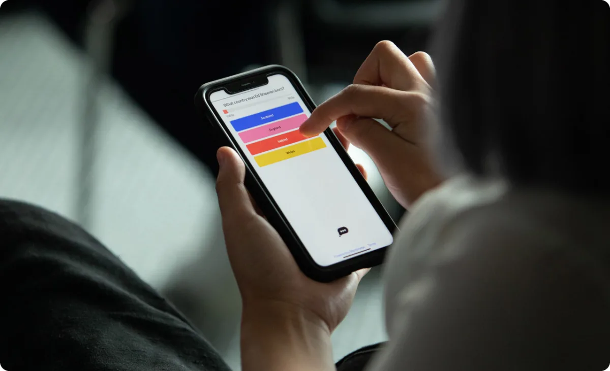 Woman participating in Mentimeter poll on smartphone.