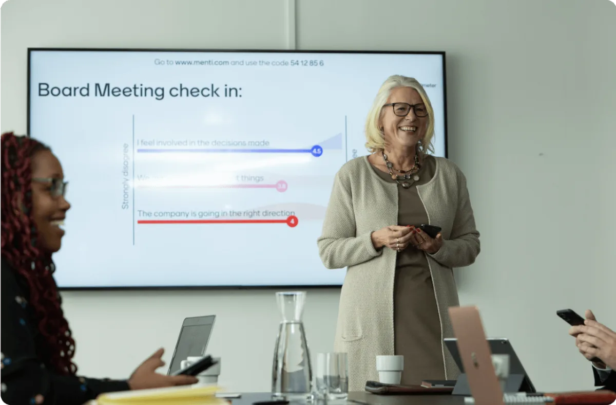Woman presenting a board meeting check in using Mentimeter. 