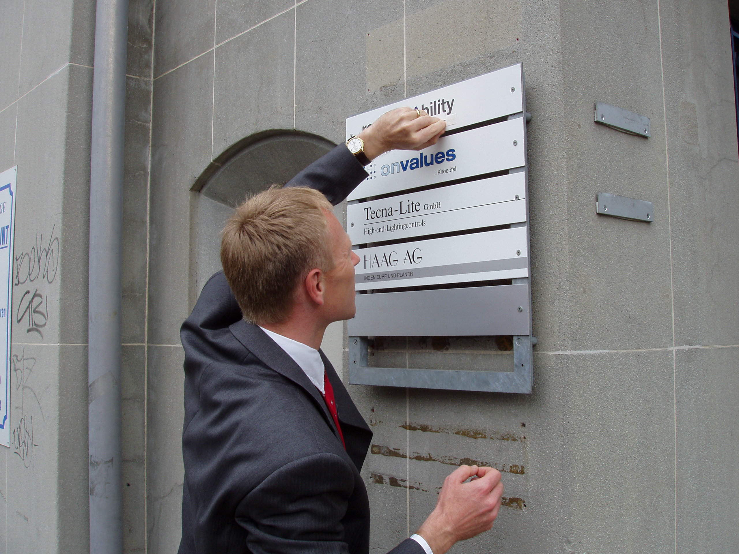 Klaus Tischhauser bringt das responsAbility Schild am neuen Büro an