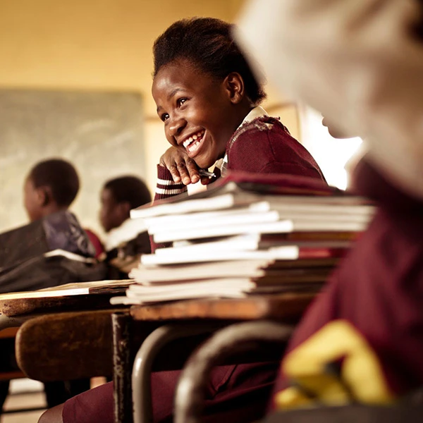 Girls holding Always products in classroom