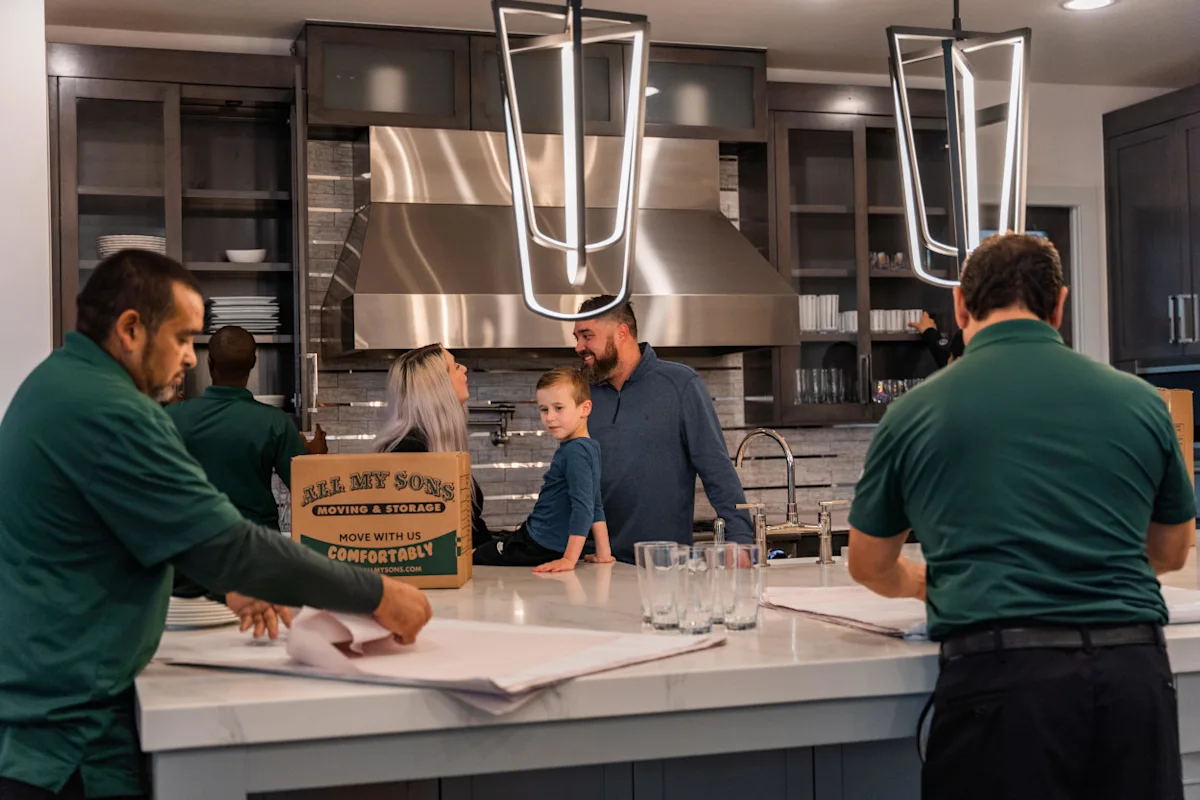 All My Sons professional packers wrap glassware in packing paper for a move.