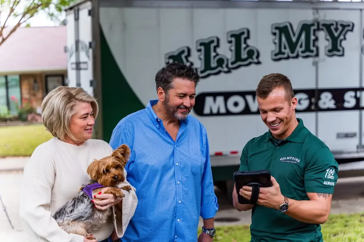 Couple with dog consults with an All My Sons team member as he reviews their moving charges.