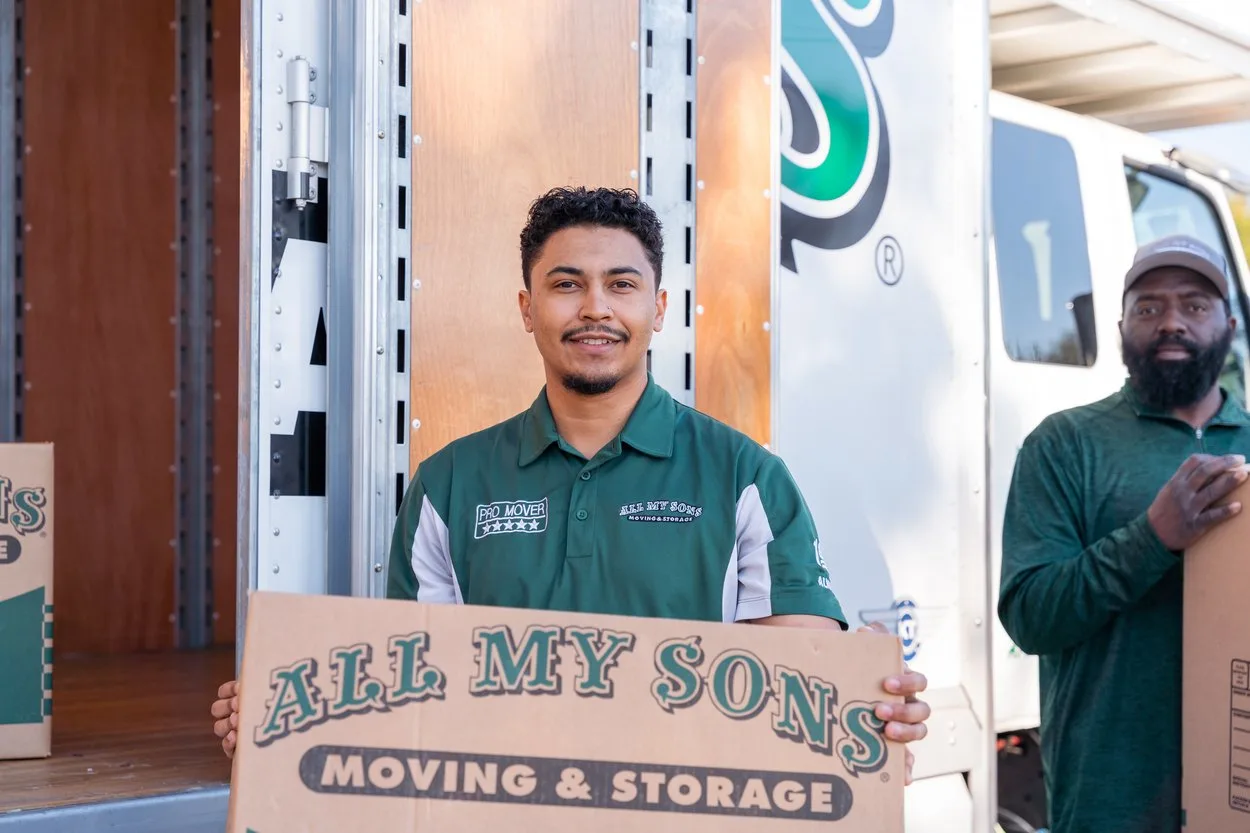Professional movers from All My Sons carry media boxes with CDs, DVDs, and Blu-rays.