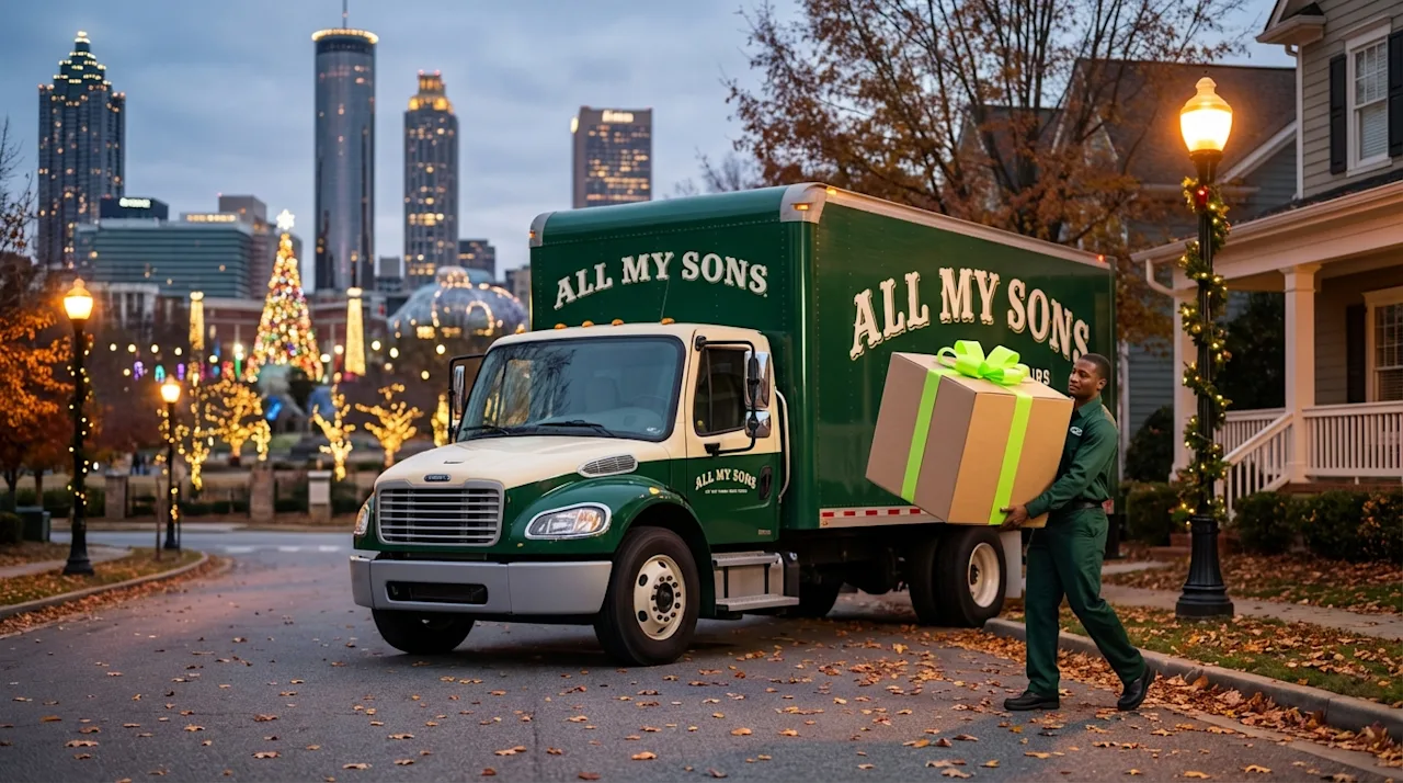 All My Sons mover carrying a gift box by a green moving truck in festive Atlanta during the holidays.