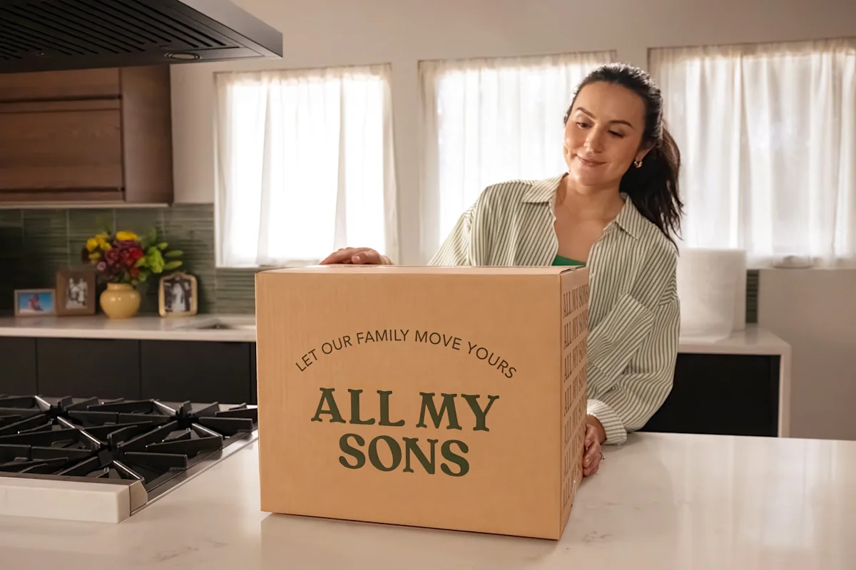 A customer prepares her kitchen for a remodeling project by packing an All My Sons Moving & Storage box for moving into storage. 