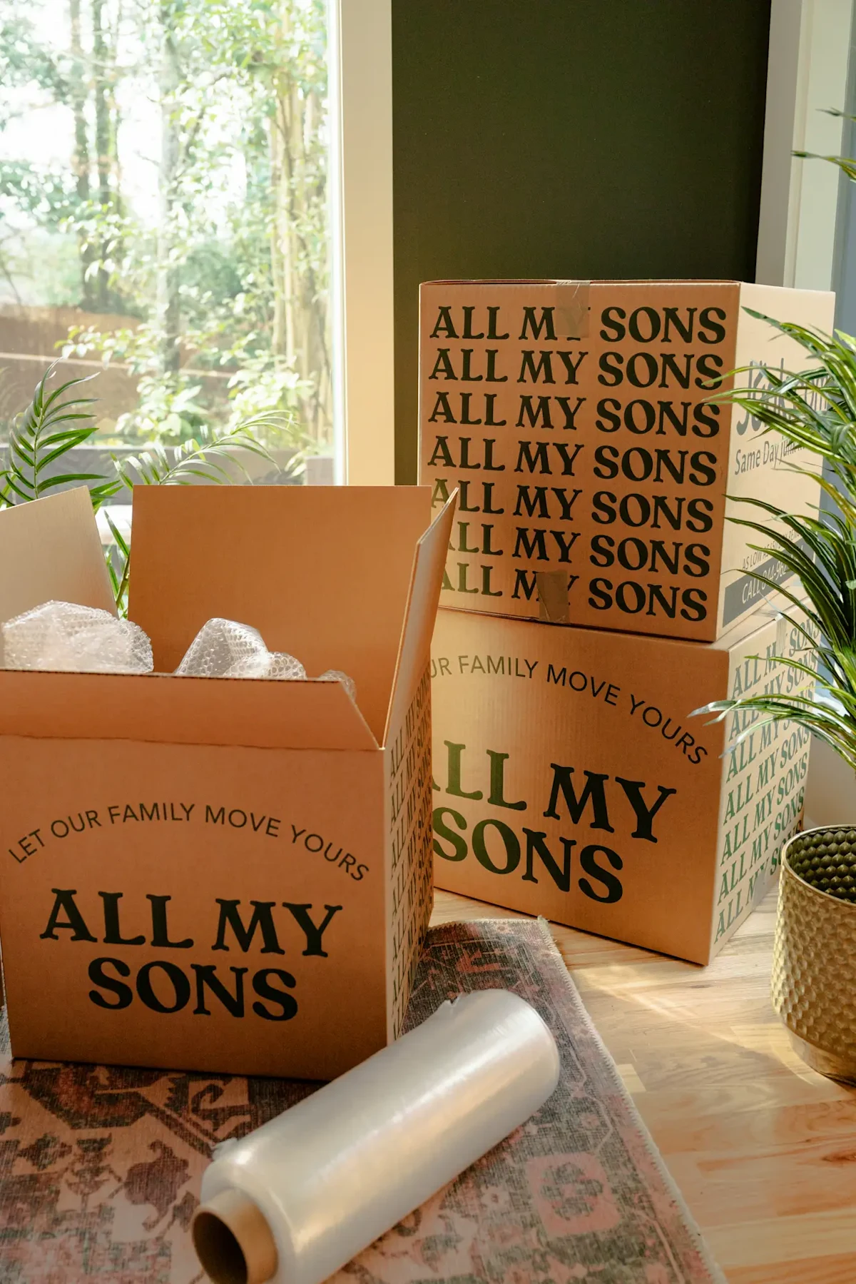 A stack of All My Sons Moving Boxes with packing supplies like bubble wrap.