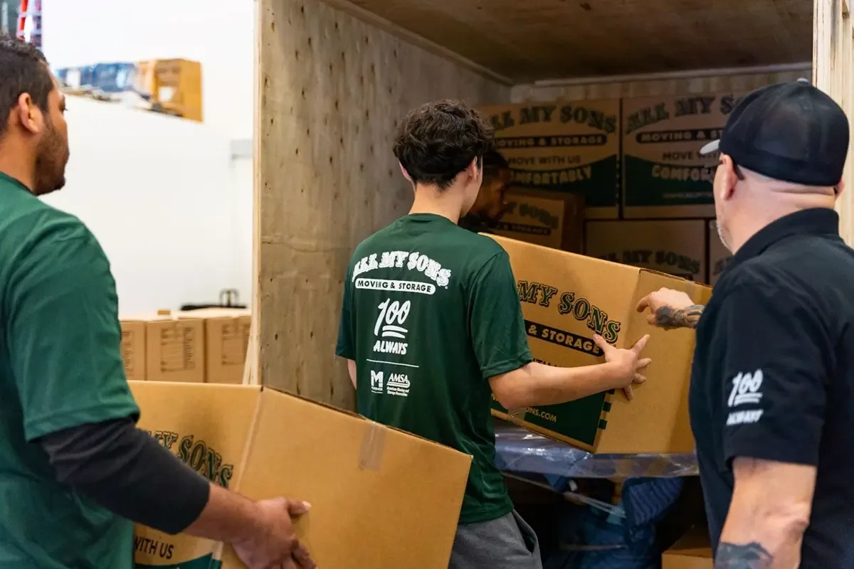 All My Sons Movers load a storage unit with boxes.