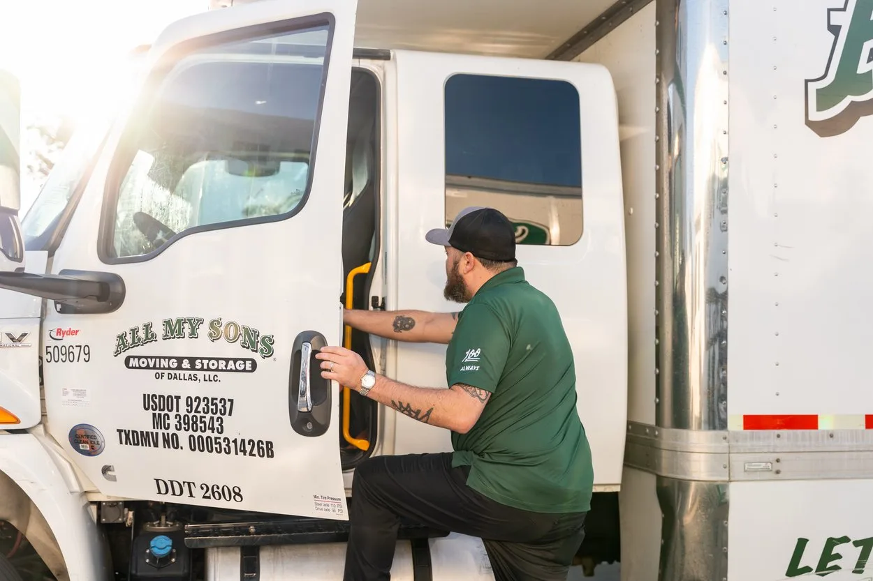 Professional moving driver from All My Sons gets into a moving truck cab to prepare for a summer move.