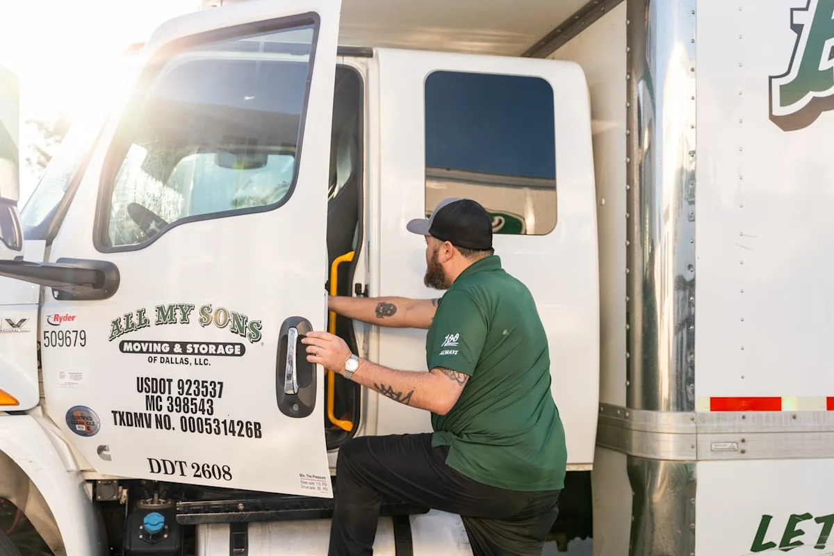 Professional moving driver from All My Sons gets into a moving truck cab to prepare for a summer move.