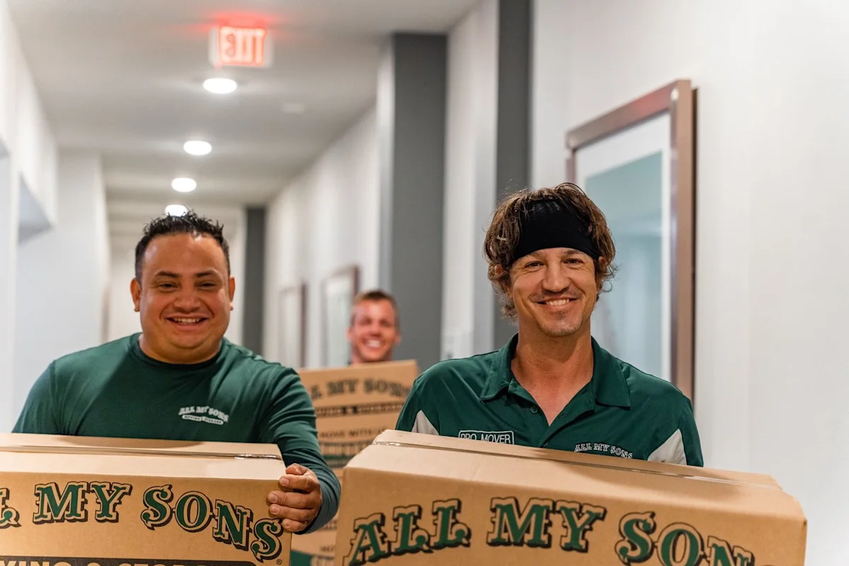 Professional movers from All My Sons Moving and Storage move boxes into a college dorm.