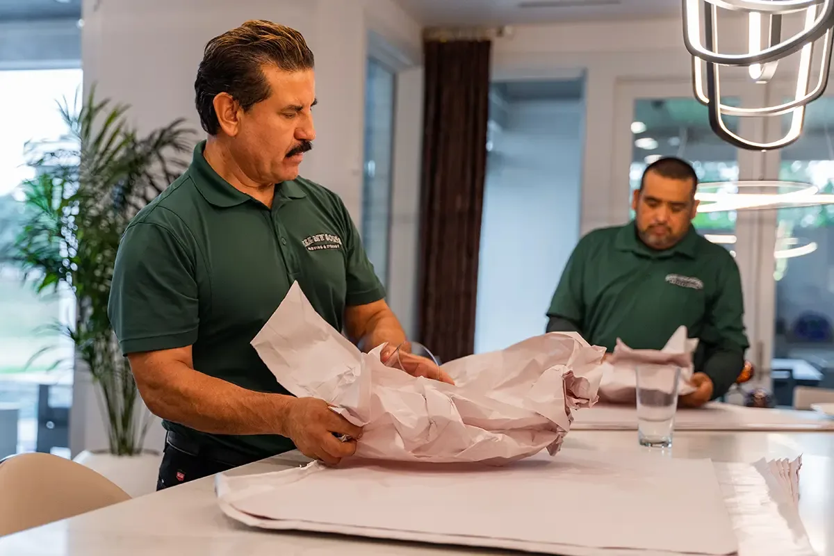 Professional packers from All My Sons Moving and Storage prepare glassware for transport.