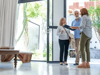 Couple with realtor in a home. Getty Images