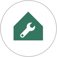 Circle with a green house with a wrench in the center