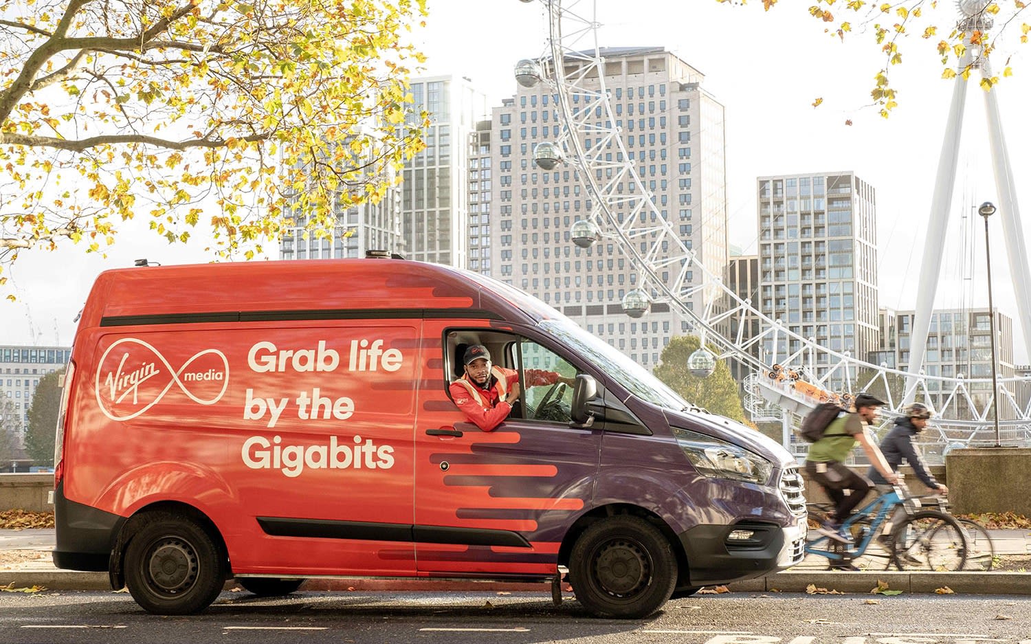 A Virgin Media van driving through London, the text on the side of the van reads: "Grab life by the Gigabits"